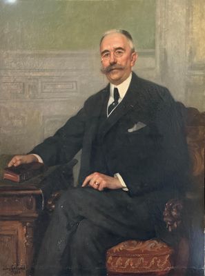 portrait d'un homme en costume, assis sur une chaise
