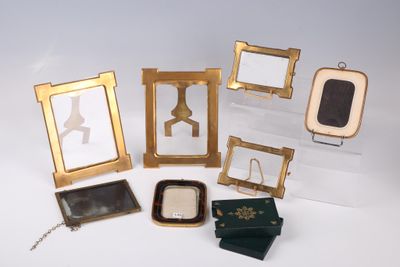 a group of small picture frames and a mirror on a table
