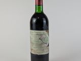 une vieille bouteille de vin posée sur une table blanche