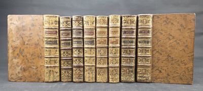 six old books sitting on top of each other on a table