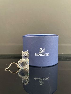 une petite figurine représentant un chat assis à côté d'une boîte bleue