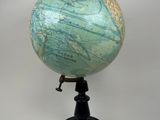 a small blue and green globe on a black stand