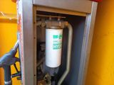 a gas pump in the corner of a yellow wall