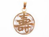 un gros plan d'un pendentif plaqué or orné d'un symbole chinois