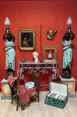 a room with a table, chair, vases, and statues