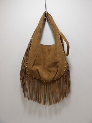 a brown purse hanging on a wall with a hook