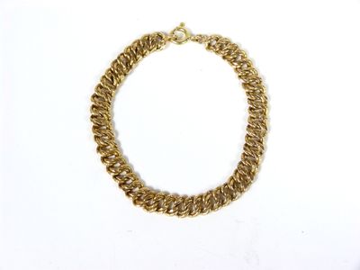 gros plan d'un bracelet en chaîne en or sur fond blanc