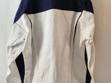 the back of a white and blue jacket hanging on a wall