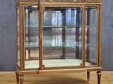 an old wooden display case with glass doors on top of a wooden floor
