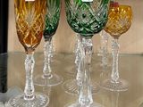 de nombreux verres à vin de différentes couleurs posés sur une table en verre