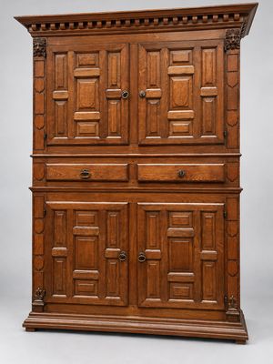 une grande armoire en chêne avec des panneaux sculptés et une porte
