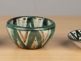 three bowls and spoons sitting on a wooden table