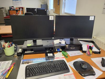 un bureau équipé de deux écrans d'ordinateur et d'un clavier