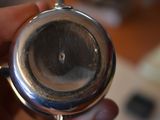 a person holding a silver pocket watch in their hand