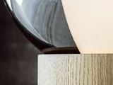 close up of a table lamp with a wooden base and a glass shade