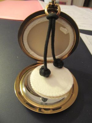 une petite montre de poche en or entourée d'une corde
