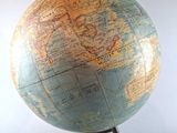 a small globe that is on a stand on a table