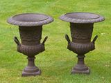 two vases that are sitting in the grass