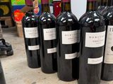 several bottles of red wine are lined up on a table
