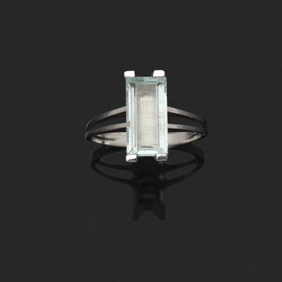 une bague sertie d'une aigue-marine et de diamants sur un fond noir