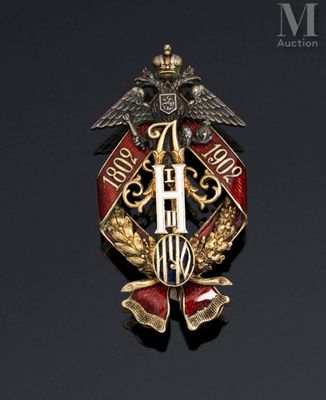 an image of a gold and red broochle with two birds on it