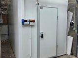 a large white freezer in a garage next to a wall