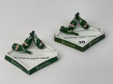 une paire de cendriers verts et blancs posés sur une table blanche