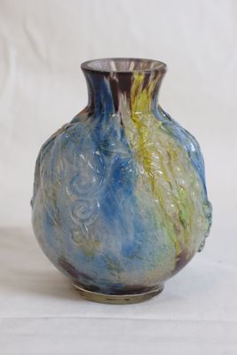 a blue and yellow vase sitting on a white surface