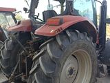 a red tractor that is parked in the dirt