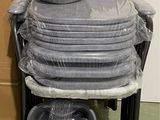 a stack of plastic plates and bowls on a cart