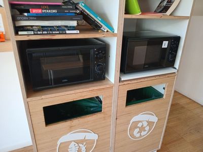 un micro-ondes et un four à micro-ondes posés sur une étagère en bois