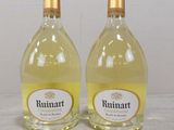 two bottles of wine sitting on top of a table next to each other