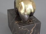 statue of a cat on a marble block on a gray background