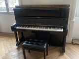 a piano in the corner of a room with a bench