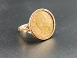 an image of a gold coin ring with a face on it