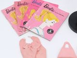 a barbie doll and other items laid out on a table
