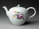 un gros plan d'une théière blanche décorée de fleurs