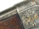 an old gun with a wooden handle on a white surface