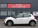 une petite voiture blanche garée devant un hôtel