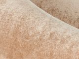 the back of a beige velvet chair with a rounded back and arms