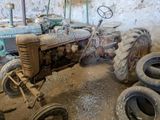 un vieux tracteur posé dans une pièce sale, avec ses pneus posés par terre