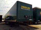 two green semi trucks parked next to each other in a parking lot
