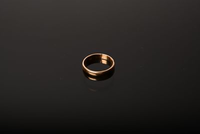 a gold ring sitting on top of a black surface