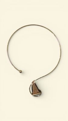 a close up of a necklace with a triangle on it