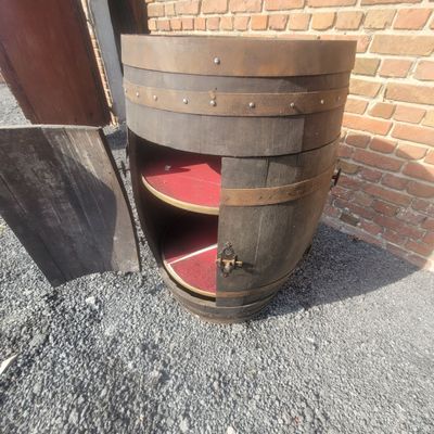 a close up of a wooden barrel with a shelf underneath it