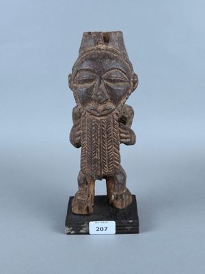 une vieille statue en bois représentant un homme barbu coiffé d'un chapeau