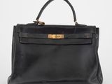un sac à main en cuir noir avec des ferrures dorées sur la poignée
