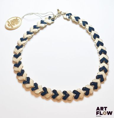 Le collier est en cuir bleu et blanc, avec un fermoir plaqué or.