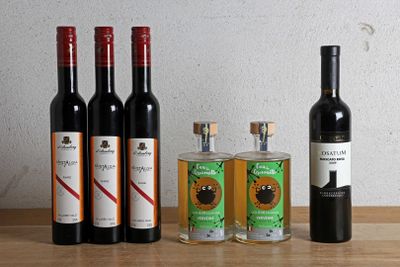 plusieurs bouteilles de vin sont alignées sur une table en bois