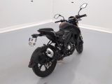 a black motorcycle parked in a room with a white wall